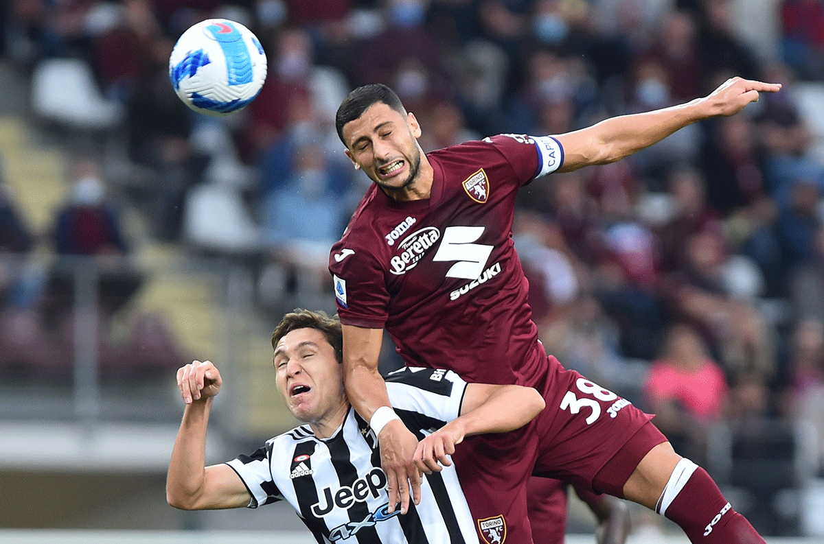 Juventus' Federico Chiesa and Torino's Rolando Mandragora in an aerial battle for possession during their La Liga match at Stadio Olimpico Grande Torino in Turin