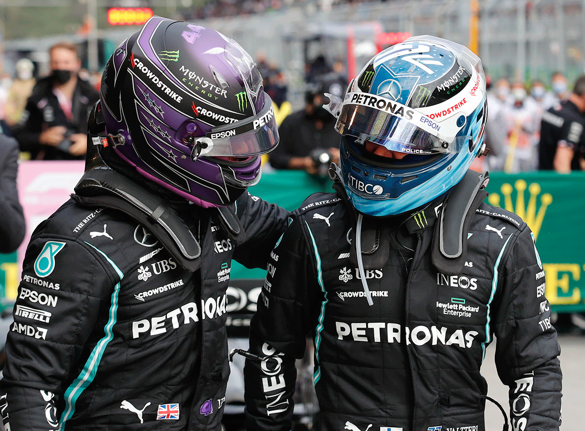 Mercedes' Lewis Hamilton celebrates qualifying in pole position with Valtteri Bottas who qualified in second position but Hamilton was later handed a 10-place grid penalty, giving Bottas the pole position in qualifying. 