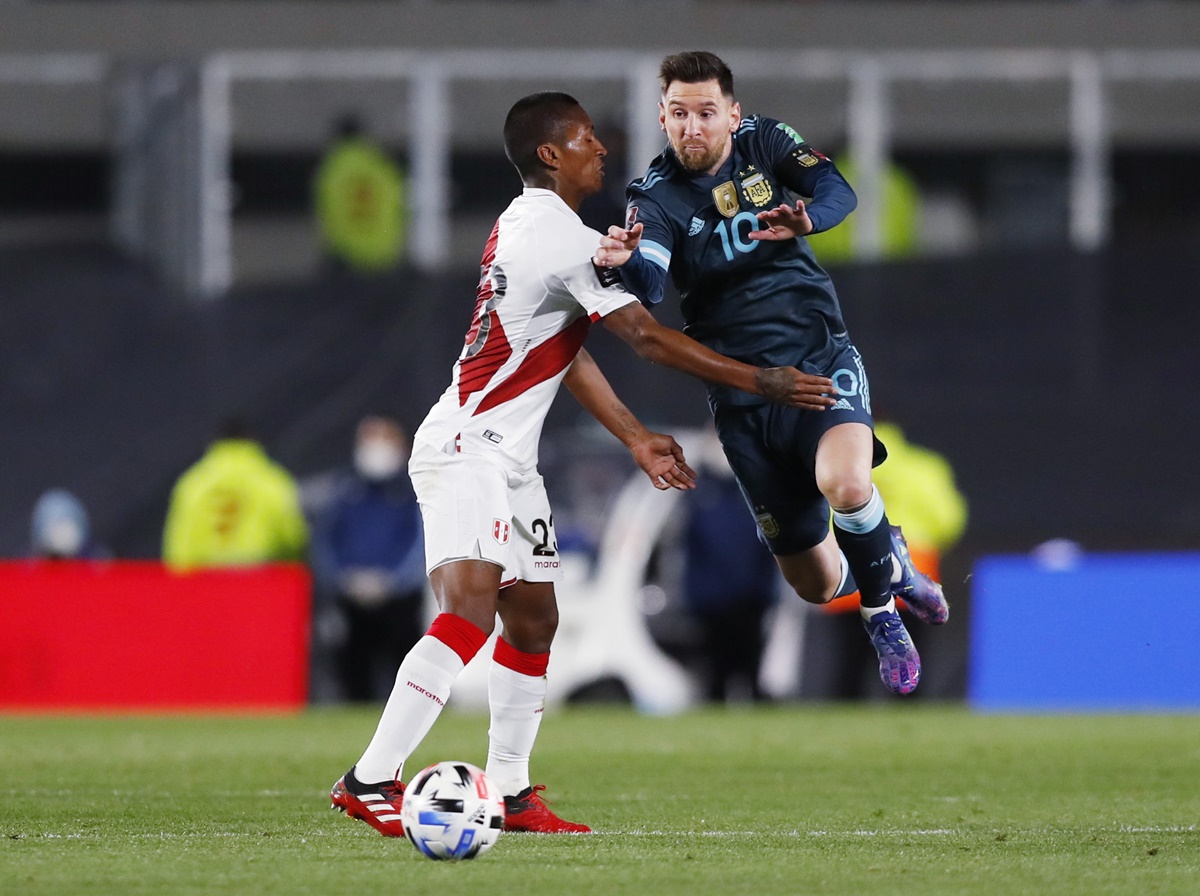 Argentina's Lionel Messi is checked in his stride by Peru's Pedro Aquino. 