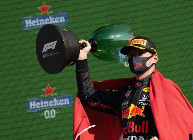 Red Bull's Max Verstappen celebrates on the podium with the trophy after winning the Formula One Dutch Grand Prix, at Circuit Zandvoort, Netherlands, on Sunday.