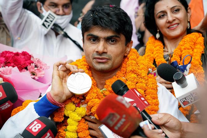 Suhas Lalinakere Yathiraj, who won a silver in badminton, shows off his medal amid loud applause from fans at IGI airport