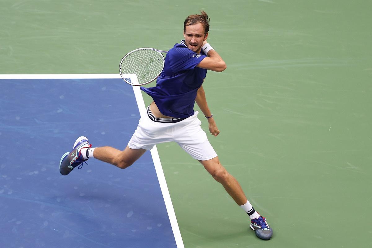 Daniil Medvedev returns the ball against Novak Djokovic