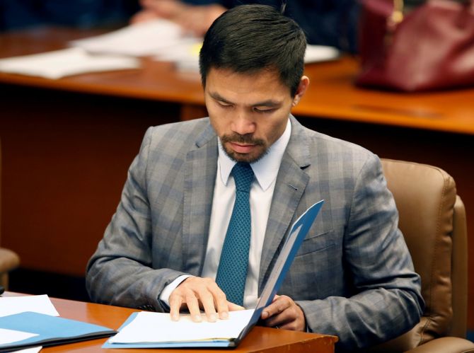 Philippine Senator and boxing champion Manny Pacquiao reads his briefing materials as he prepares for a Senate session in Pasay city, Metro Manila, Philippines.
