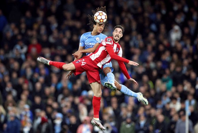 Manchester City's Nathan Ake beats Atletico Madrid's Sime Vrsaljko in an aerial duel for the ball.
