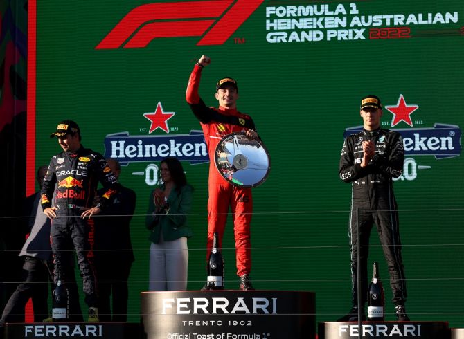 Ferrari's Charles Leclerc celebrates on the podium after winning the F1 Australian Grand Prix, at Melbourne Grand Prix Circuit, with second placed Red Bull's Sergio Perez and third placed Mercedes' George Russell.