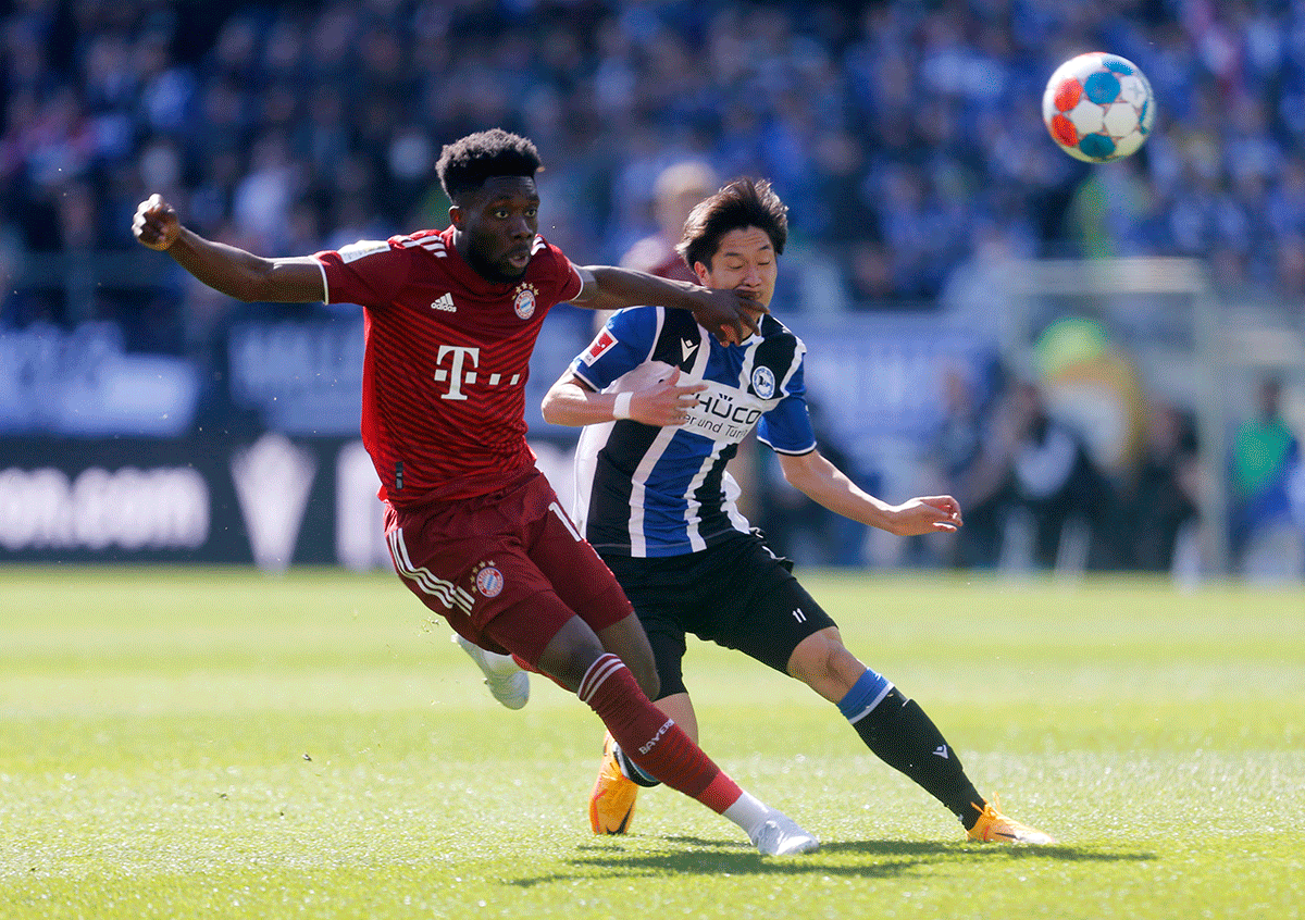 Bayern Munich's Alphonso Davies in action with Arminia Bielefeld's Masaya Okugawa at Bielefelder Alm, Bielefeld, Germany, on Sunday