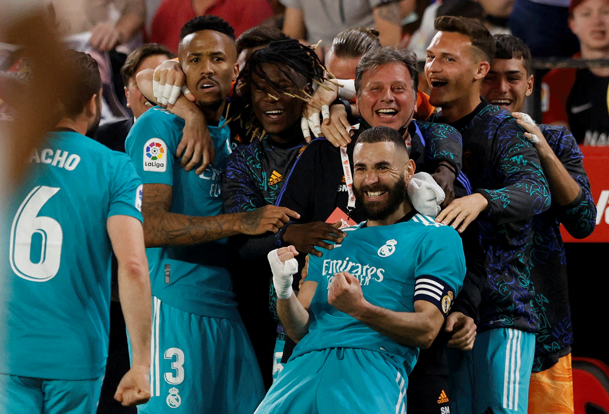 Real Madrid's Karim Benzema celebrates with teammates after scoring their third goal against Sevilla at Ramon Sanchez Pizjuan, Seville on Sunday 