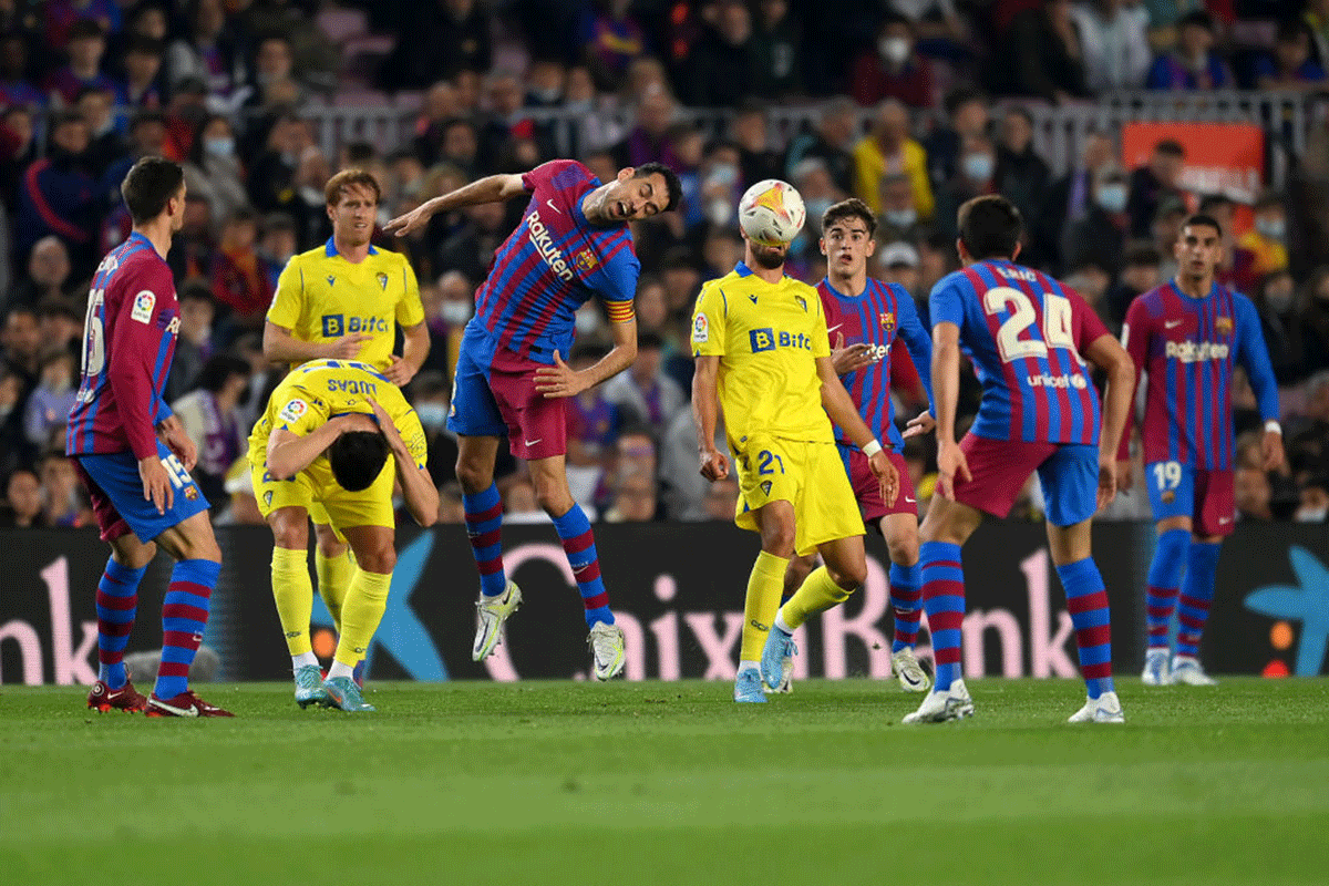 Barcelona's Sergio Busquets contends for the aerial ball with Cadiz's Ruben Sobrino