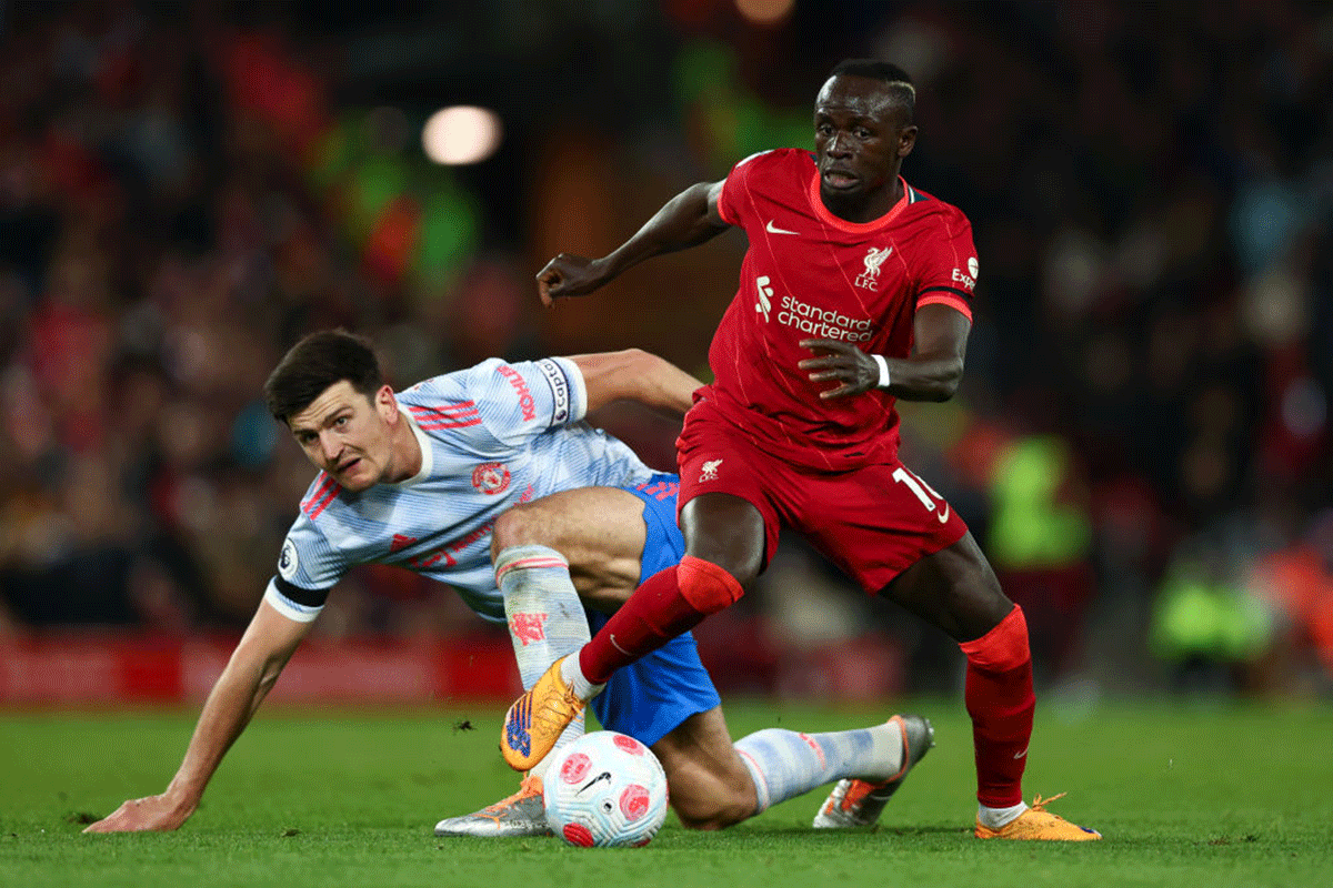 Sadio Mane runs with the ball past Harry Maguire 