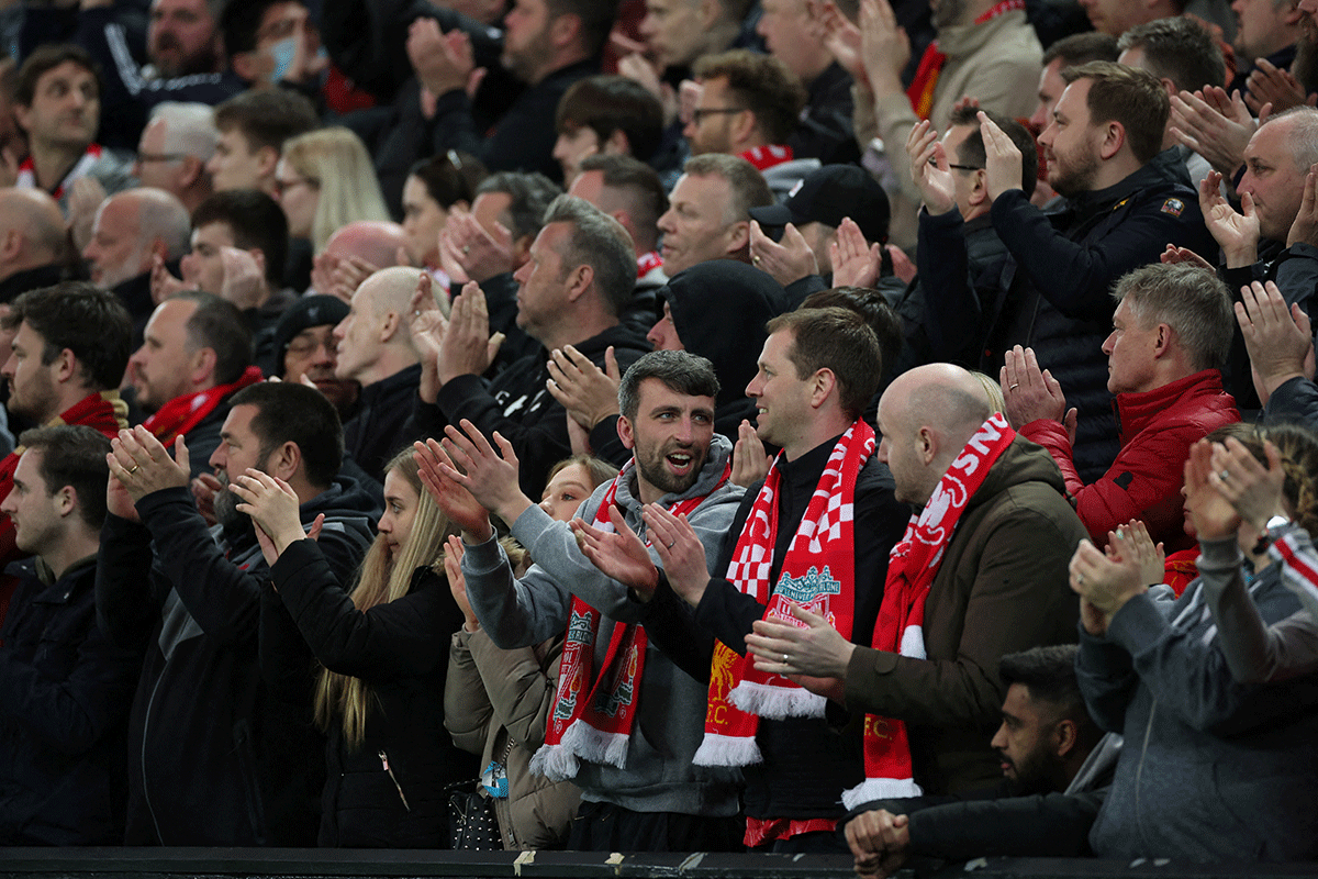 Liverpool fans applaud on the seventh minute for Manchester United 's Cristiano Ronaldo and his family during their EPL match at Anfield in Liverpool on Tuesday