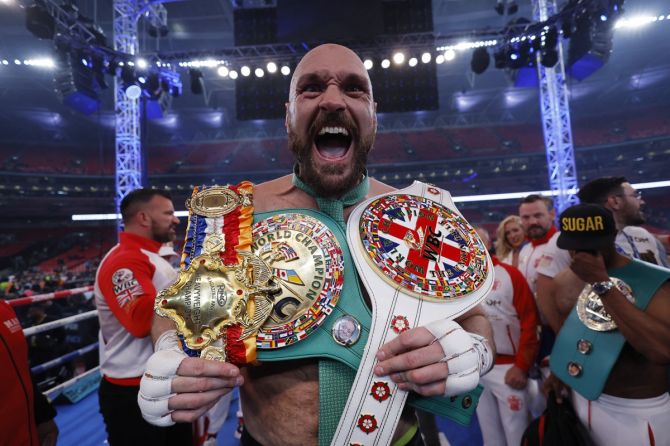 Tyson Fury celebrates with the belts after winning his WBC World Heavyweight title bout against Dillian Whyte, at Wembley Stadium, London, on Saturday.