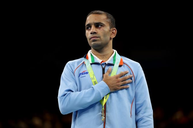 Gold medalist Amit Panghal celebrates on the podium after beating England’s Kiaran MacDonald in the Commonwealth Games men's 48kg-51kg Flyweight boxing final, at NEC Arena in Birmingham, on Sunday.