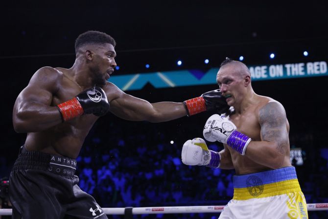 Anthony Joshua lands a punch on Oleksandr Usyk during their WBA, WBO and IBF heavyweight bout.