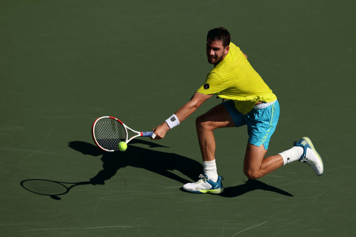 Great Britain's Cameron Norrie plays a backhand against France's Benoit Paire