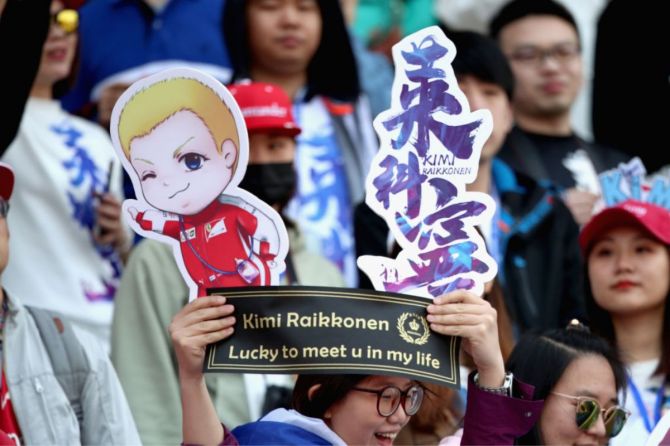 Fans of Kimi Raikkonen and Ferrari get excited before the Formula One Grand Prix of China