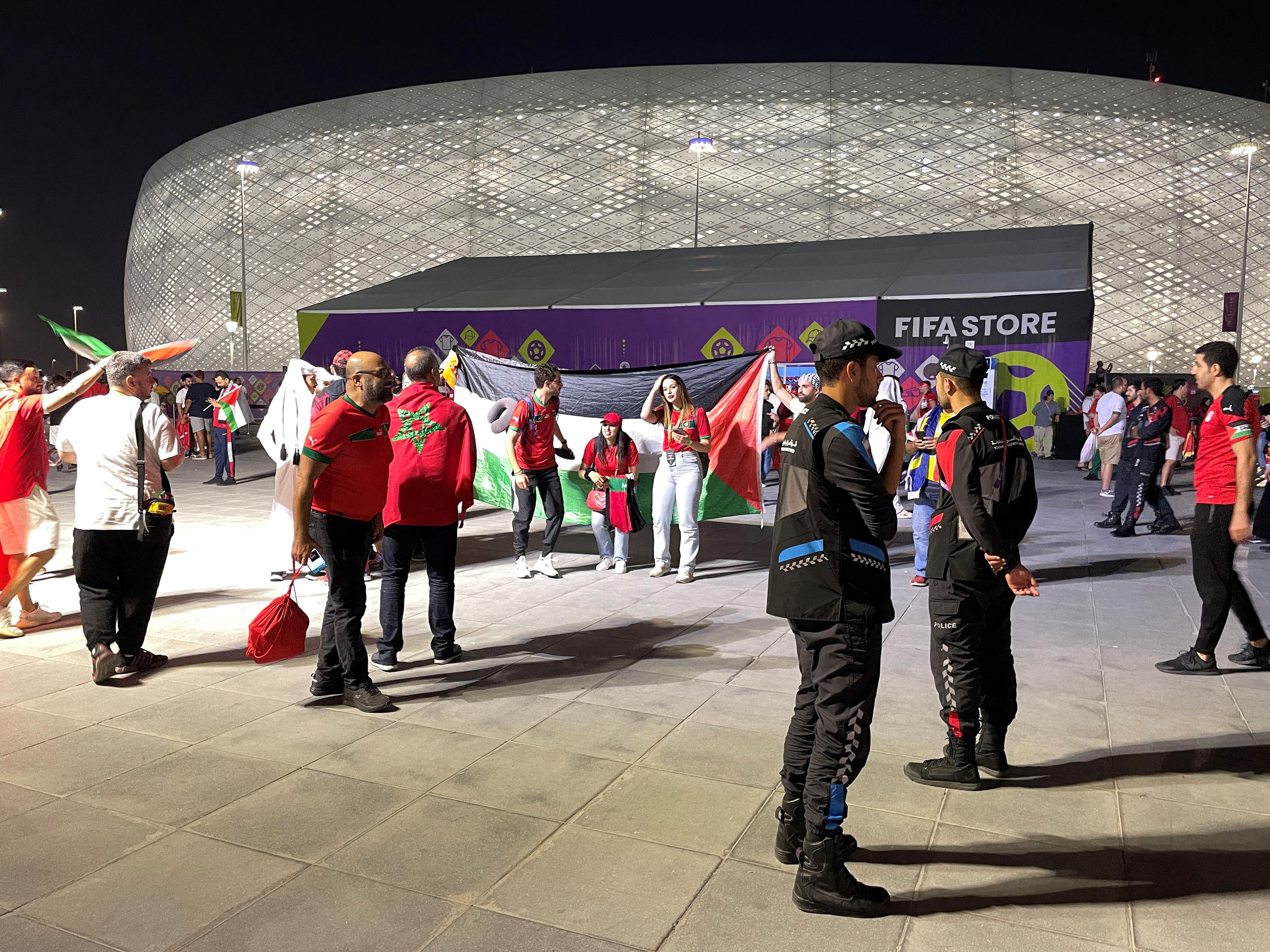 Fans hold a Palestine flag outside the stadium