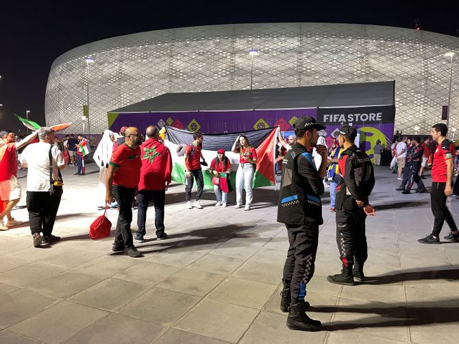 Fans hold a Palestine flag outside the stadium