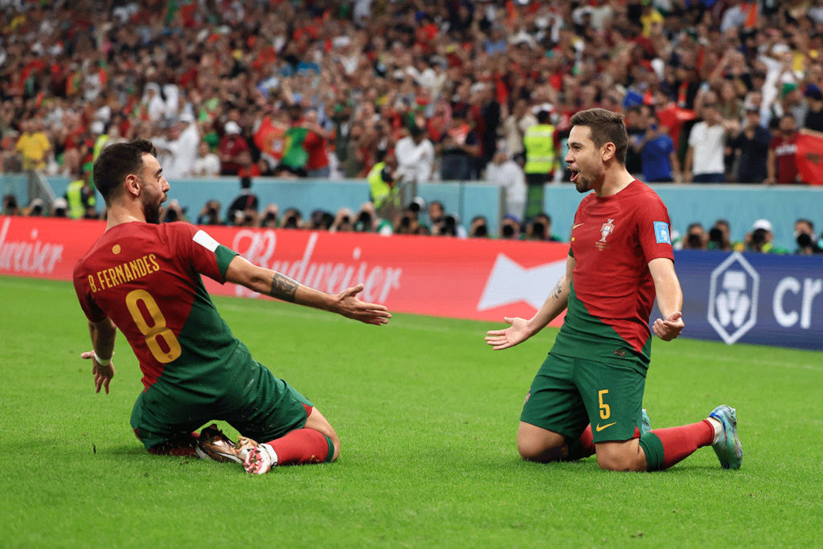 Portugal's Raphael Guerreiro celebrates with teammate Bruno Fernandes on netting the fourth goal