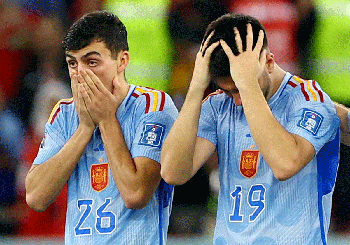 Spain's Pedri and Carlos Soler look dejected after Sergio Busquets has his penalty saved by Morocco's Yassine Bounou during the penalty shootout during their Round of 16 match 