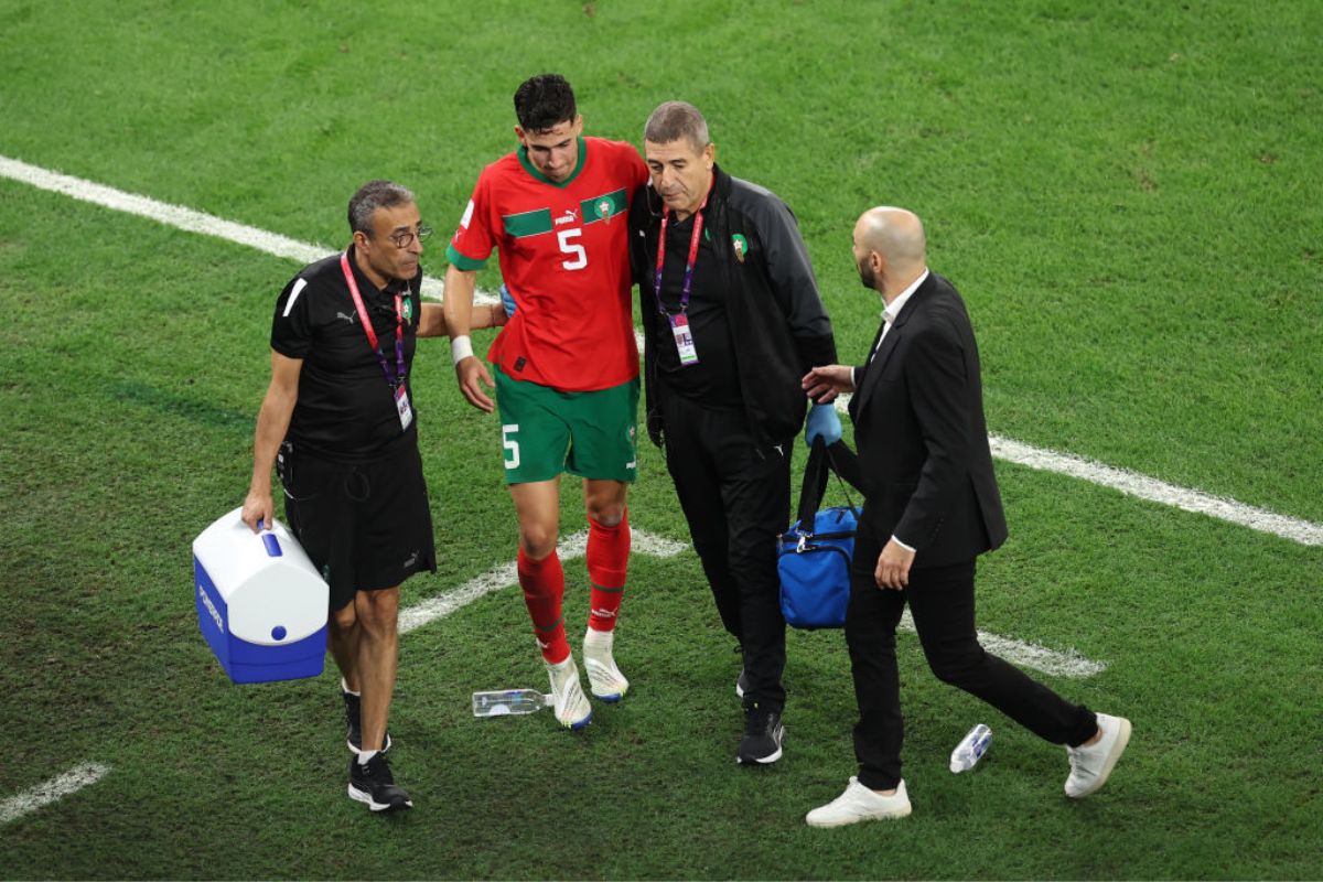 Nayef Aguerd of Morocco receives medical attention during the match between Morocco and Spain