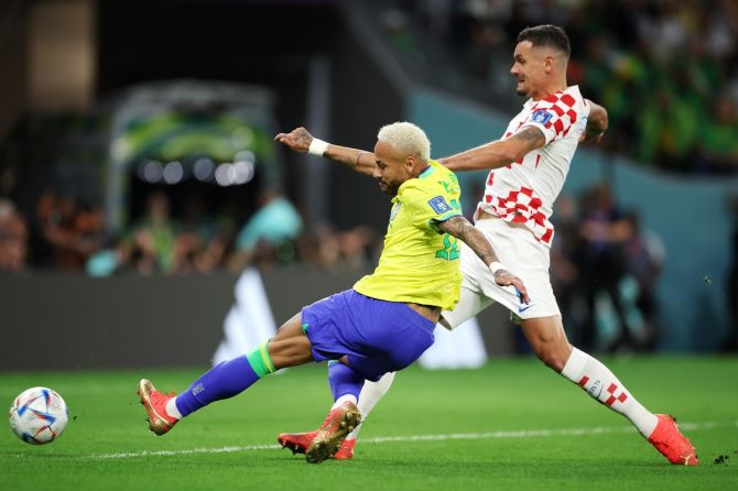 Neymar staves off a challenge from Croatia's Dejan Lovren to fire a shot at goal.