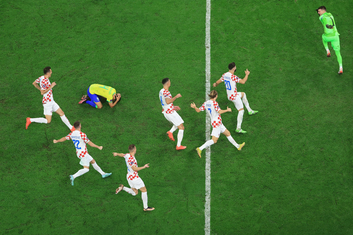 Croatia players celebrate their win via a penalty shootout as Marquinhos of Brazil reacts