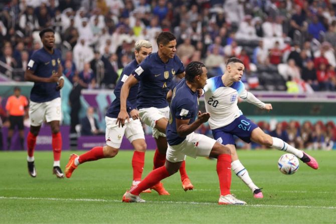 England's Phil Foden shoots while France's Raphael Varane and Jules Kounde attempt to block 