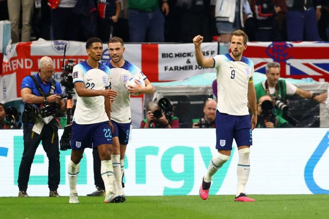 England's Harry Kane celebrates scoring their first goal with Jude Bellingham and Jordan Henderson