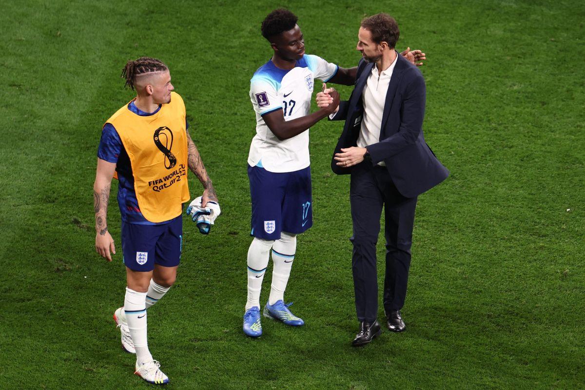 England's Bukayo Saka and Kalvin Phillips celebrate with manager Gareth Southgate after the match