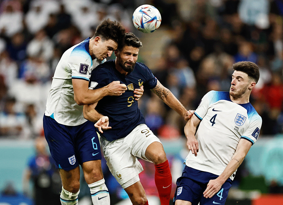 England's Harry Maguire and France's Olivier Giroud battle for possession in an aerial duel 