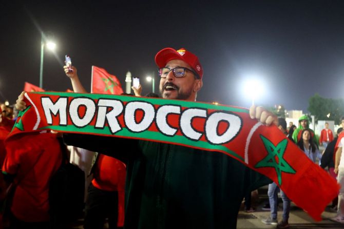 A Morocco fan celebrates outside the stadium after the match