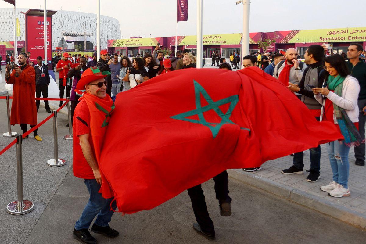 Morocco fans are pictured with the flag of Morocco outside the stadium before the match