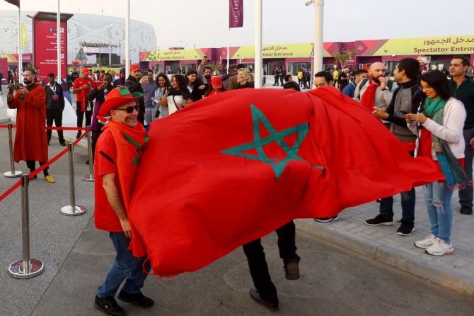 Morocco fans are pictured with the flag of Morocco outside the stadium before the match