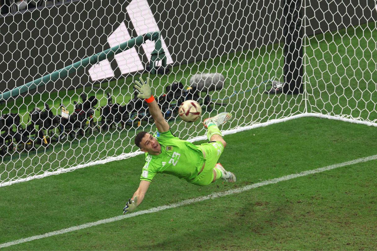 Emiliano Martinez of Argentina concedes the first penalty to Kylian Mbappe of France in the penalty shootout