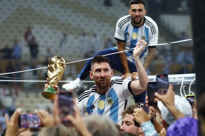 Argentina's Lionel Messi celebrates with the trophy after winning the World Cup