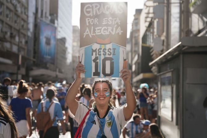 A fan of Argentina holds a board with a gratitude message for Lionel Messi