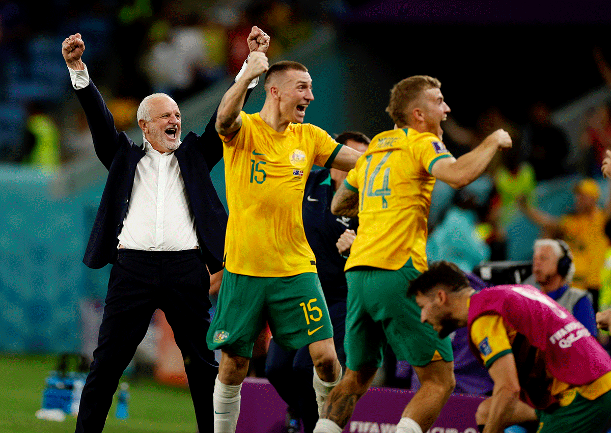 Australia coach Graham Arnold celebrates with Australia's Riley McGree and Australia's Mitchell Duke after qualifying for the knockout stages