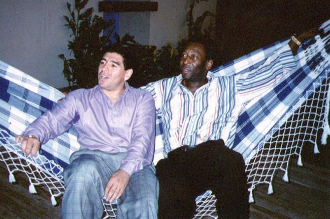Soccer legends Diego Maradona and Pele rest on a hammock during a reception in Rio de Janeiro