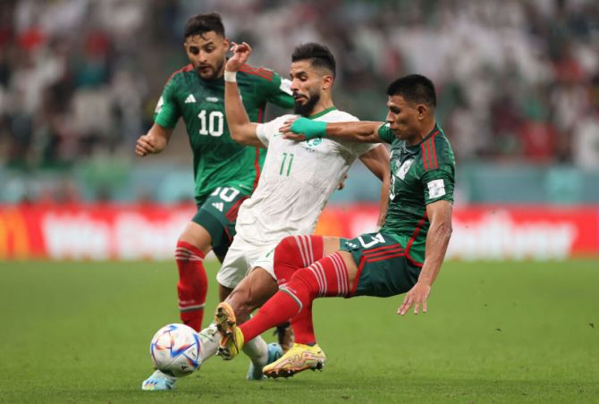 Saleh Al-Shehri of Saudi Arabia controls the ball under pressure of Alexis Vega and Jesus Gallardo of Mexico
