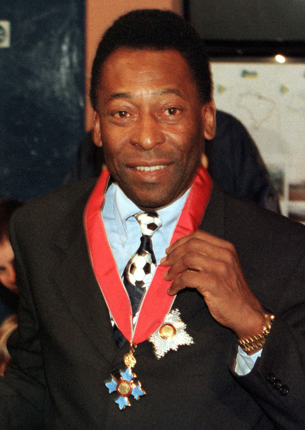 Pele, (L), shows off his KBE (Knight Commander of the British Empire) medal awarded to him by Queen Elizabeth II December 3, 1997