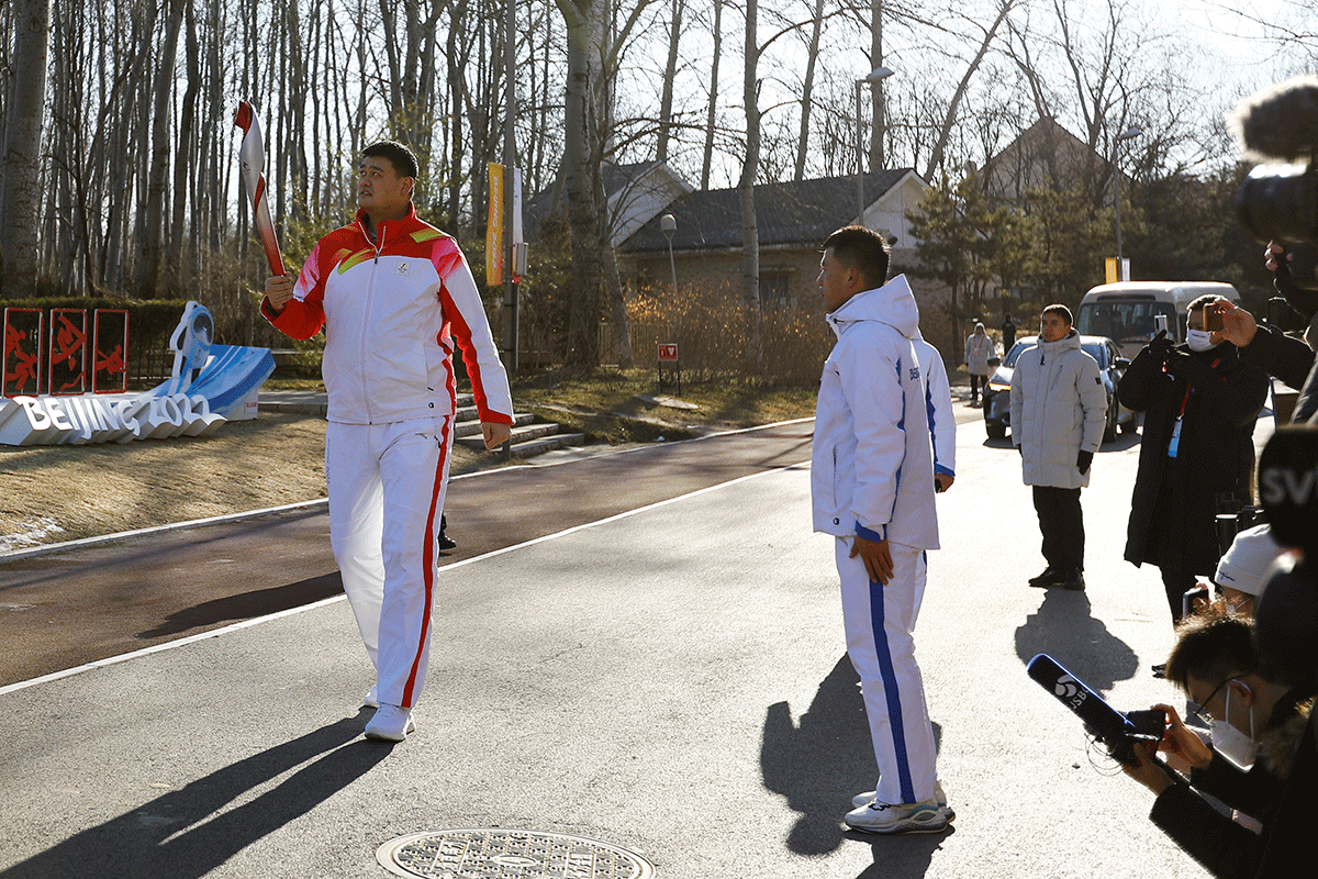 President of Chinese Basketball Association and Ice and Snow Sports Promotion Ambassador Yao Ming relays the Olympic flame at the Olympic Forest Park in Beijing on Wednesday