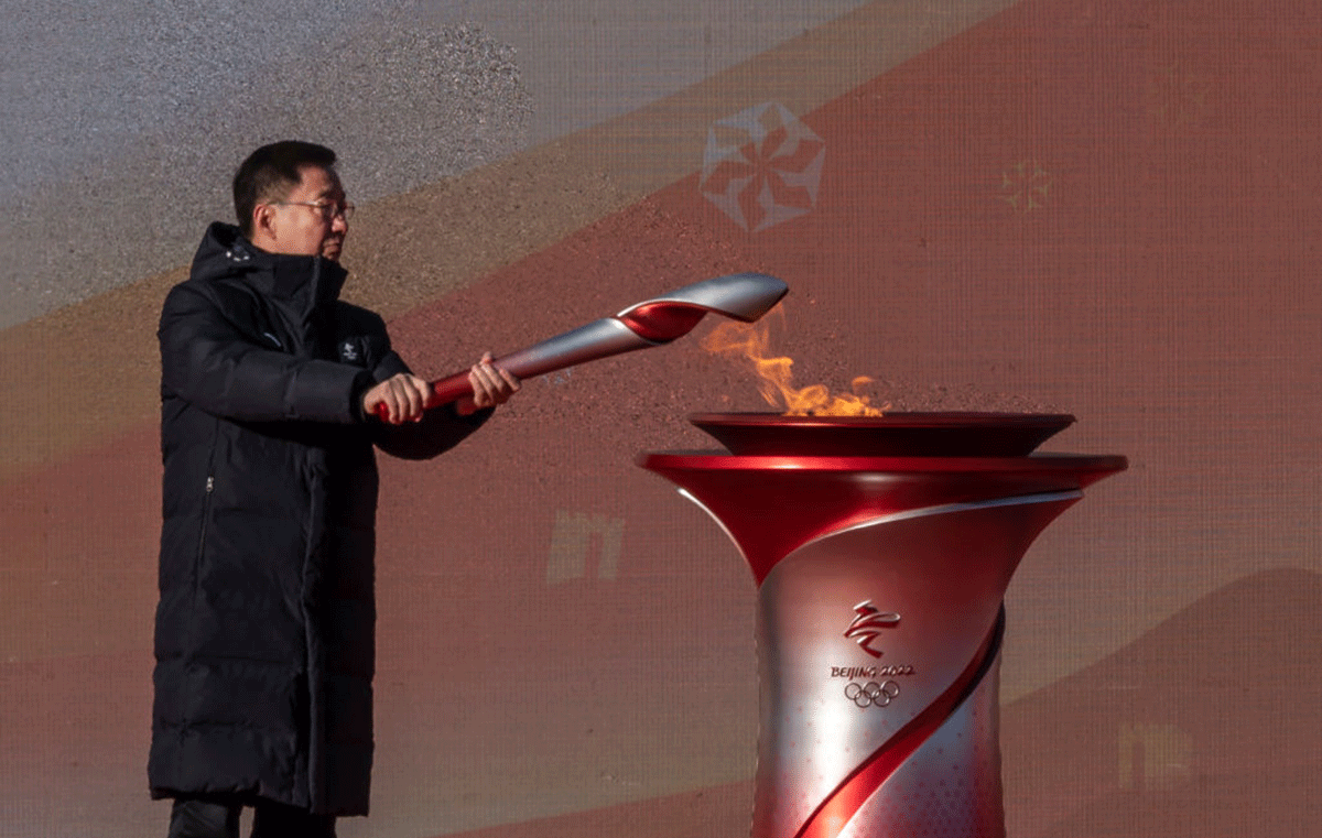 China's Vice Premier Han Zheng lights the torch during the launch ceremony for the Beijing 2022 Winter Olympics Torch Relay in front of the Olympic Tower outside of the closed loop bubble at Olympic Park in Beijing on Wednesday