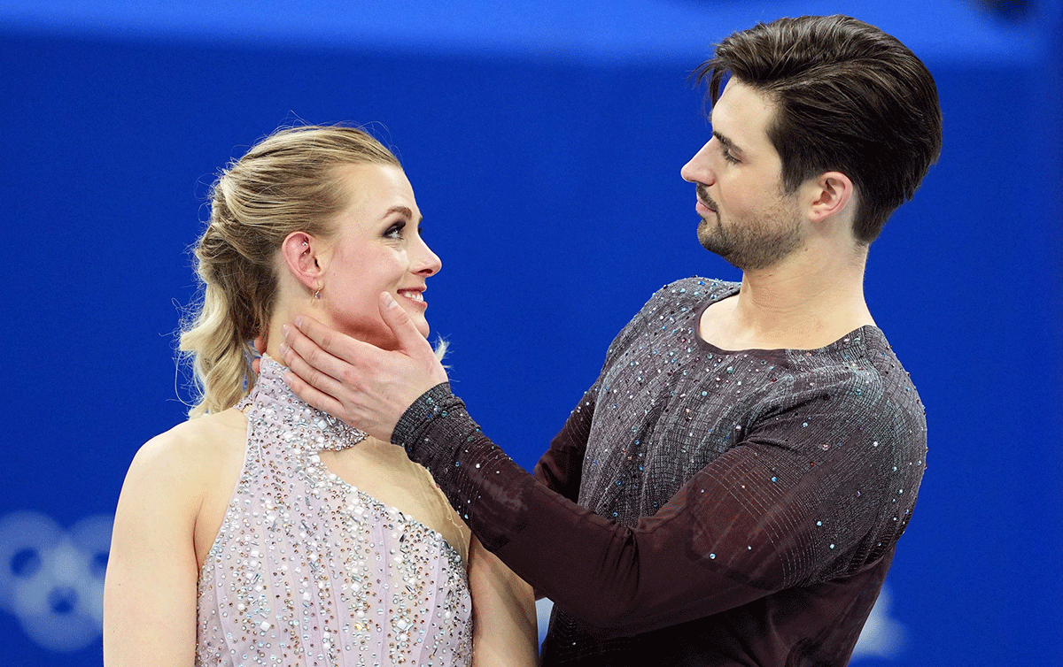 United States' ice dancers Zachary Donohue and Madison Hubbell celebrate on the podium after winning Bronze in Figure Skating Ice Dance Free Dance event at Capital Indoor Stadium, Beijing on Monday