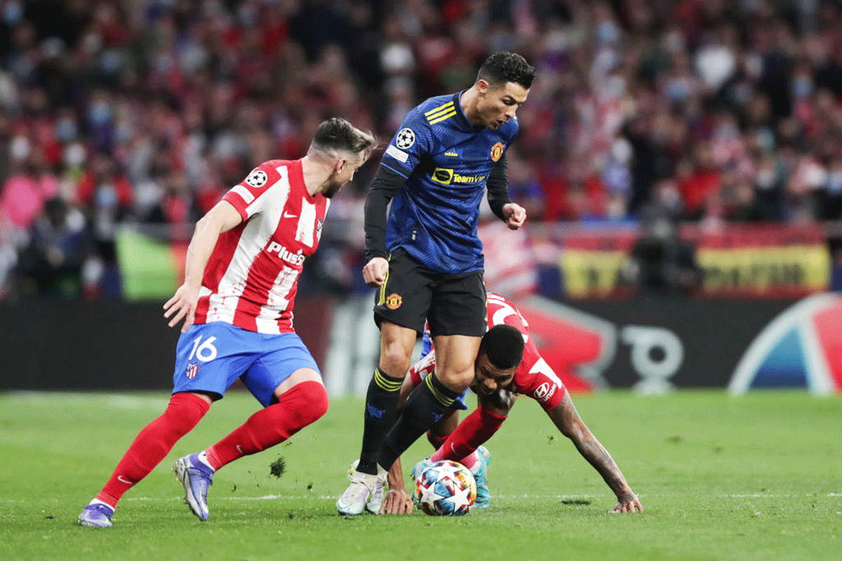 Manchester United's Cristiano Ronaldo (2ndL) tackles Atletico de Madrid's Reinildo Mandava (right) during their UEFA Champions League Round Of Sixteen Leg One match at Wanda Metropolitano in Madrid