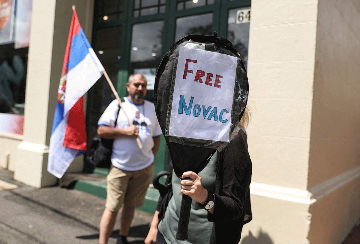 A supporter of Serbian tennis player Novak Djokovic holds up a sign outside the Park Hotel, where the star athlete is believed to be held while he stays in Australia, in Melbourne. 