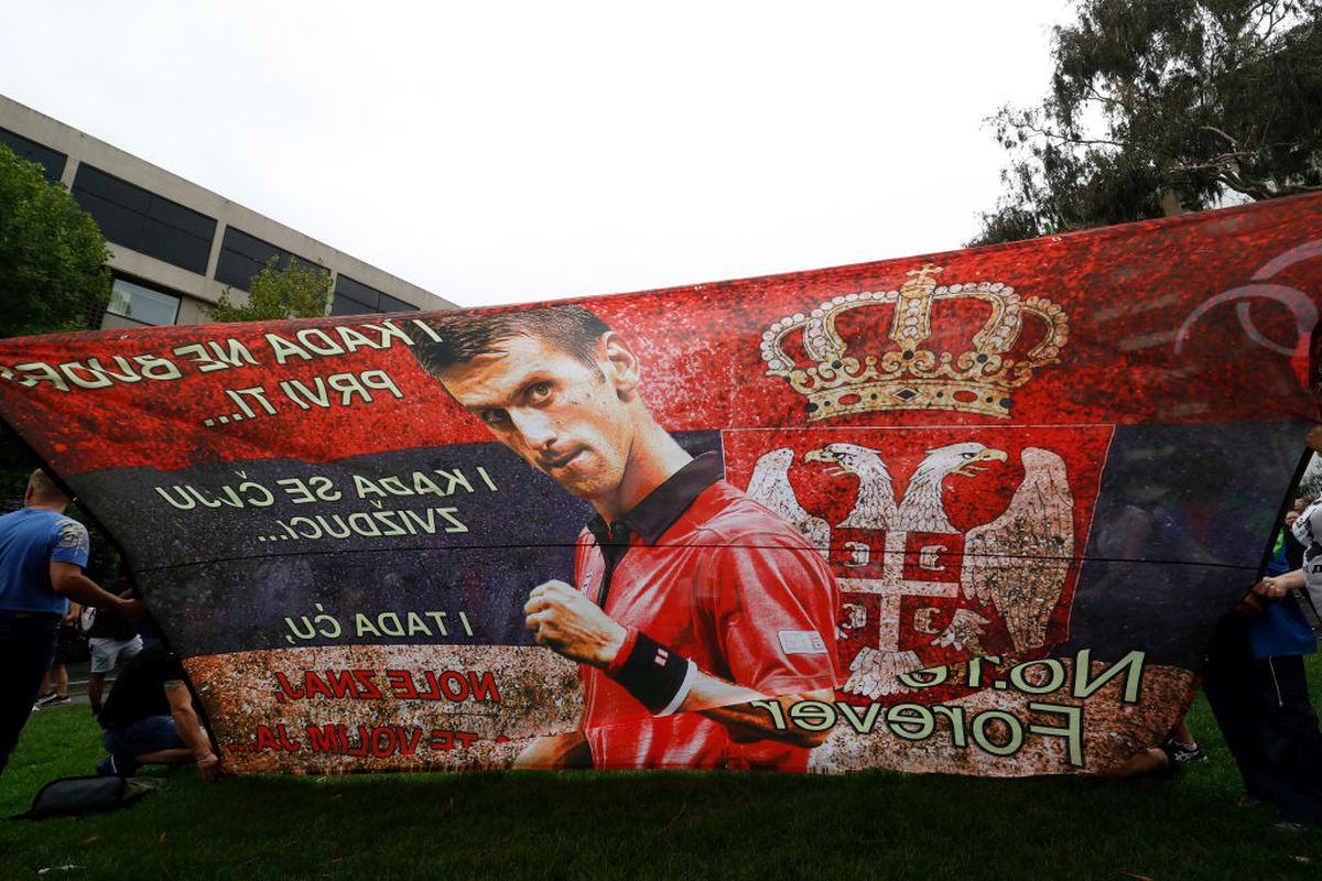 Serbian tennis fans and anti vaccination protesters are seen outside the Park Hotel in Melbourne on Friday