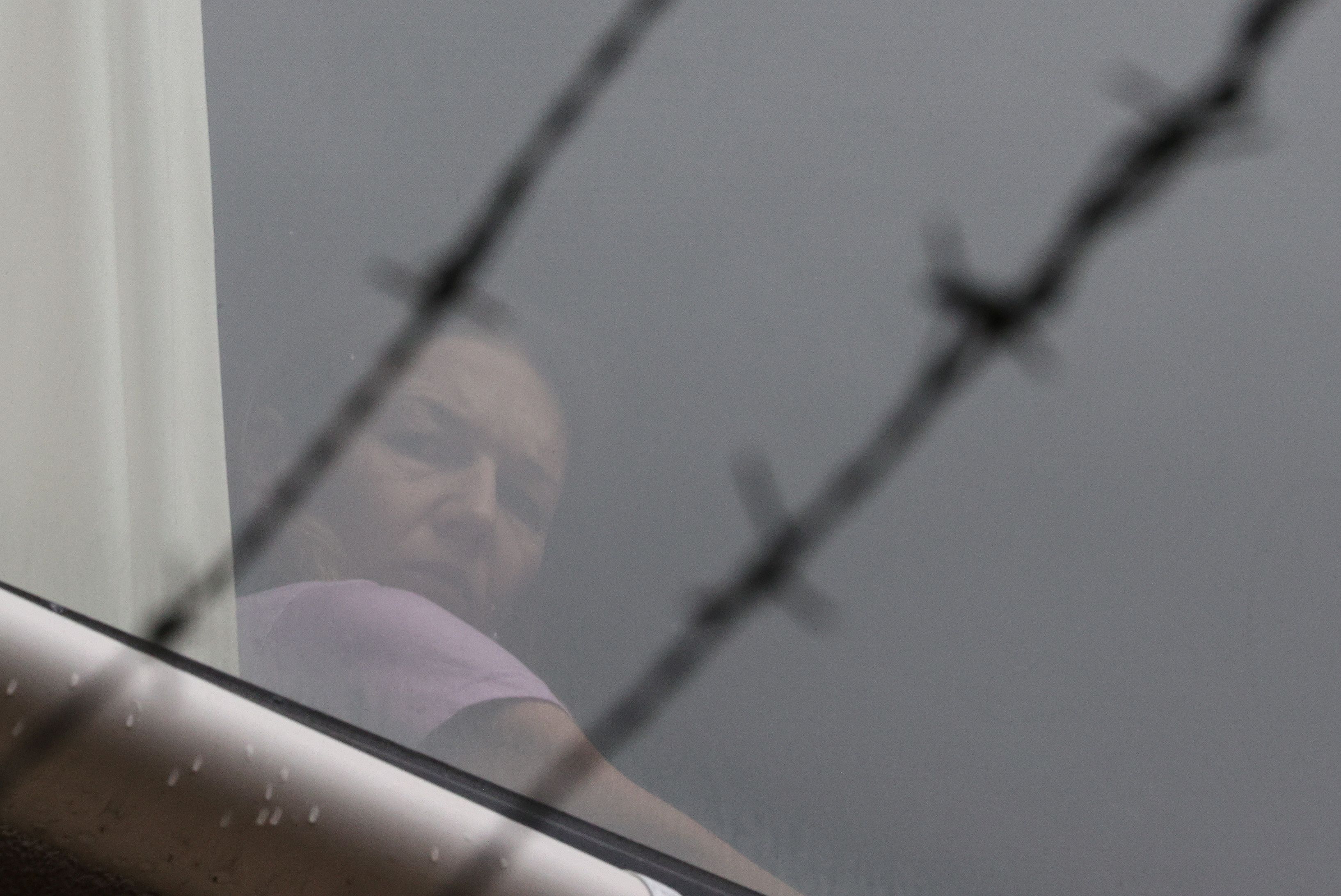 Tennis player Renata Voracova of the Czech Republic looks out a window at the Park Hotel where she is being held while she stays in Australia following the cancellation of her visa, the same government facility where Serbian tennis player Novak Djokovic is believed to be, in Melbourne, on Saturday