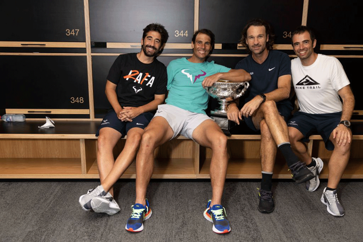 Rafael Nadal poses with the Australian Open men's singles final trophy alongside his coach Carlos Moya and members of his coaching team, in the locker room following his Australian Open win in Melboure on Sunday. 