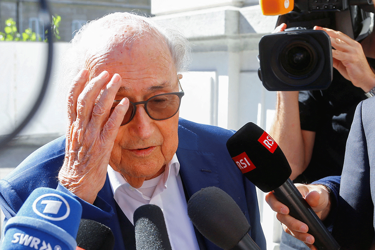 Former FIFA President Sepp Blatter talks to the media as he arrives at the Swiss Federal Criminal Court in Bellinzona, Switzerland on Friday