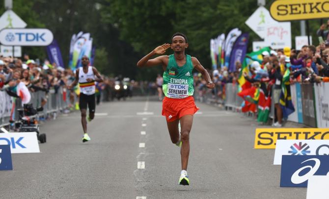 Tamirat Tola celebrates before crossing the line